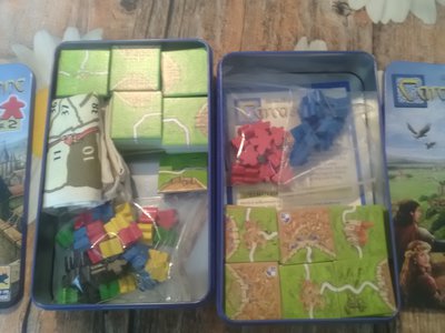 Links das Reise Carcassonne für 5 Spieler und Zählleiste und rechts der Inhalt der 2x Carcassonne für 2.